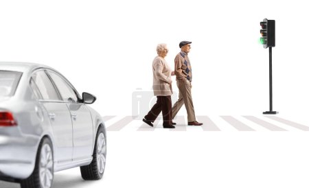 Photo for Full length profile shot of an elderly man and woman crossing street at a pedestrian crosswalk isolated on white background - Royalty Free Image