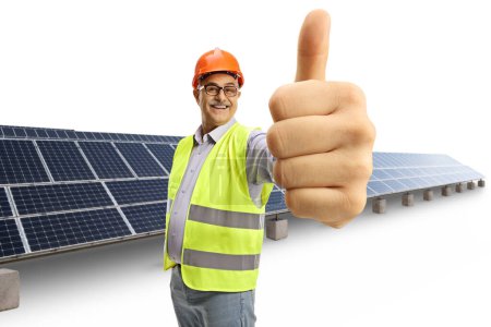 Téléchargez les photos : Ingénieur masculin mature joyeux montrant les pouces devant un champ photovoltaïque isolé sur fond blanc - en image libre de droit