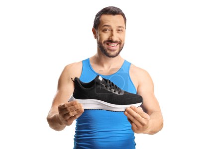 Photo for Fit young man holding a sneaker and smiling isolated on white background - Royalty Free Image