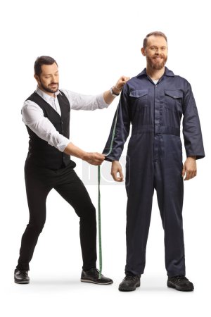 Foto de Sastre que mide un uniforme general masculino para un trabajador aislado sobre fondo blanco - Imagen libre de derechos