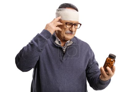 Photo for Mature man with a bandage on head holding a bottle of pills isolated on white background - Royalty Free Image