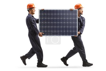 Foto de Trabajadores de la fábrica llevando un panel solar y caminando aislados sobre fondo blanco - Imagen libre de derechos