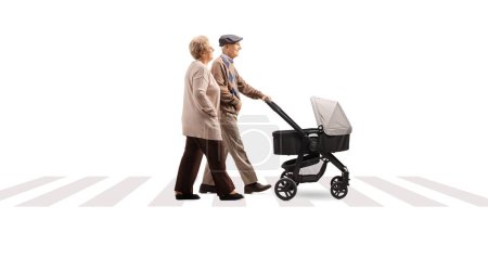 Photo for Full length profile shot of grandparents walking at a pedestrian crossing with a pushchair isolated on white background - Royalty Free Image