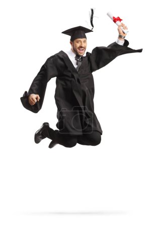 Photo for Happy male student in a graduation gown holding diploma and jumping isolated on white background - Royalty Free Image