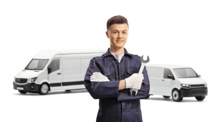 Photo for Young car mechanic holding a wrench in front of vans isolated on white background - Royalty Free Image