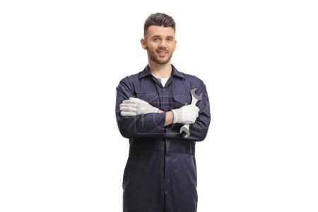 Automechaniker hält einen Schraubenschlüssel in der Hand und posiert isoliert auf weißem Hintergrund
