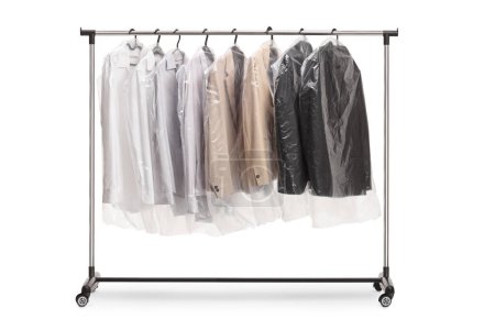 Photo for Clothing rack at dry cleaners with suits in plastic covers isolated on white backgroun - Royalty Free Image