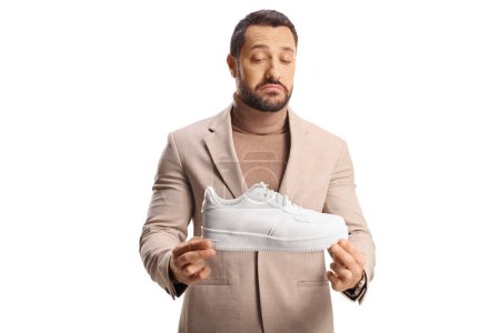 Photo for Young professional man looking at white sneakers isolated on white background - Royalty Free Image