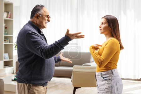 Photo for Profile shot of a father arguing with aughter at home in a living room - Royalty Free Image