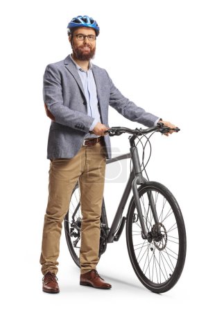 Foto de Hombre barbudo con casco de pie junto a una bicicleta y sonriendo aislado sobre fondo blanco - Imagen libre de derechos