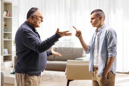 Photo for Young man threatening a mature man in a living room - Royalty Free Image