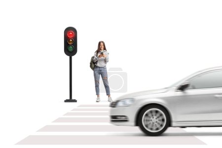 Photo for Full length portrait of a female student with a smartphone waiting at traffic lights isolated on white background - Royalty Free Image