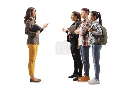 Photo for Full length profile shot of a young teacher talking to a group of teenage students isolated on white background - Royalty Free Image