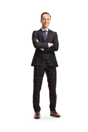 Téléchargez les photos : Portrait complet d'un homme d'affaires debout avec les bras croisés et souriant isolé sur fond blanc - en image libre de droit