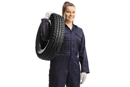 Foto de Joven trabajadora mecánica llevando un neumático aislado sobre fondo blanco - Imagen libre de derechos