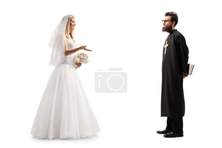 Téléchargez les photos : Plan de profil complet d'une mariée parlant à un prêtre isolé sur fond blanc - en image libre de droit