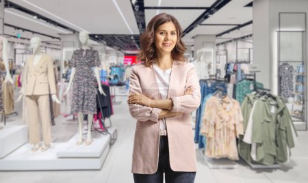 Téléchargez les photos : Femme client posant à l'intérieur d'un magasin de vêtements - en image libre de droit