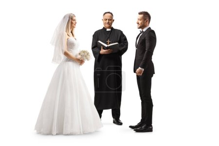 Téléchargez les photos : Officier prêtre déclarant mariée et marié comme un couple marié isolé sur fond blanc - en image libre de droit