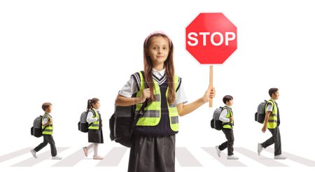 Photo for Schoolgirl with a reflective vest holding a stop sign and children crossing street at pedestrian crosswalk isolated on white background - Royalty Free Image