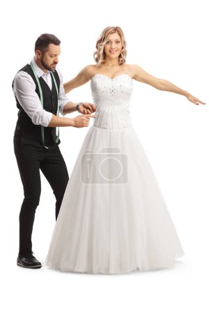 Téléchargez les photos : Prendre des mesures sur mesure pour une robe de mariée isolée sur fond blanc - en image libre de droit