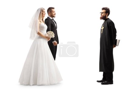 Photo for Full length profile shot of a priest and a bride and groom isolated on white background - Royalty Free Image