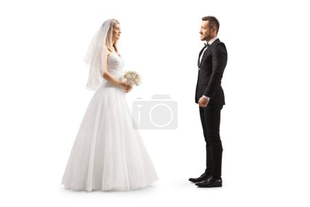 Photo for Full length profile shot of a bride looking at a groom isolated on white background - Royalty Free Image