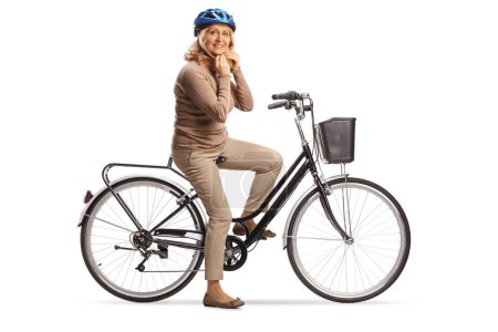 Photo for Mature woman with a bicycle putting on a helmet isolated on white background - Royalty Free Image