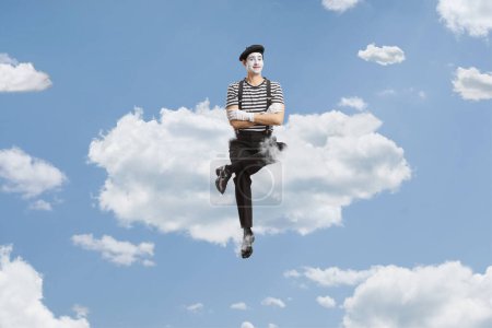 Téléchargez les photos : Portrait intégral d'un mime assis sur un nuage dans le ciel - en image libre de droit