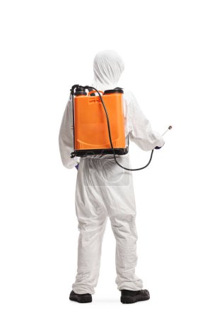 Foto de Vista trasera de un controlador de plagas en un traje de materiales peligrosos que desinfecta con un dispositivo de pulverización aislado sobre fondo blanco - Imagen libre de derechos