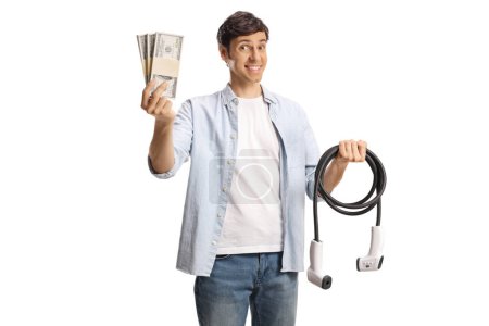 Foto de Hombre sosteniendo un cable para la carga de vehículos eléctricos y pilas de dinero aislado sobre fondo blanco - Imagen libre de derechos