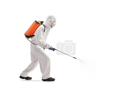 Photo for Full length profile shot of a man in a hazmat suit applying pesticide isolated on white background - Royalty Free Image