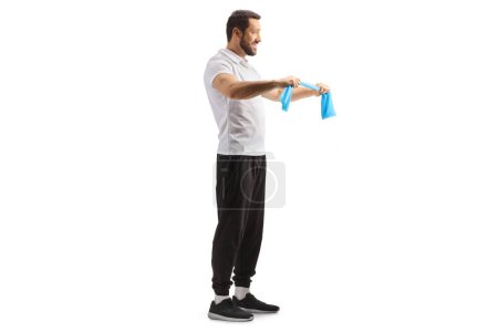 Photo for Full length profile shot of a fitness coach exercising with a resistance band isolated on white background - Royalty Free Image