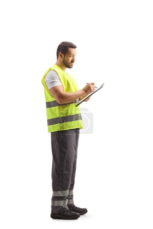 Téléchargez les photos : Travailleur de l'assistance routière en gilet réfléchissant rédigeant un document isolé sur fond blanc - en image libre de droit