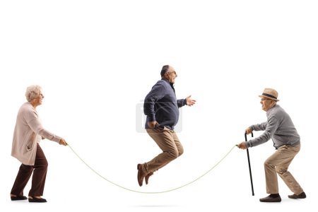Téléchargez les photos : Plan de profil complet d'un homme mature sautant une corde isolée sur fond blanc - en image libre de droit