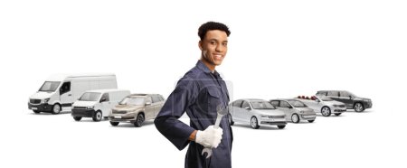 Foto de Mecánico de automóviles afroamericano sosteniendo una llave en frente de muchos vehículos aislados en fondo blanco - Imagen libre de derechos