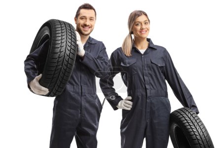Photo for Male and female car mechanic workers carrying tires isolated on white background - Royalty Free Image