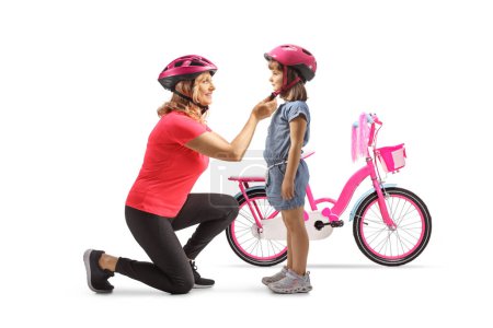Photo for Mother putting a helmet on a girl for a bicycle ride solated on white background - Royalty Free Image