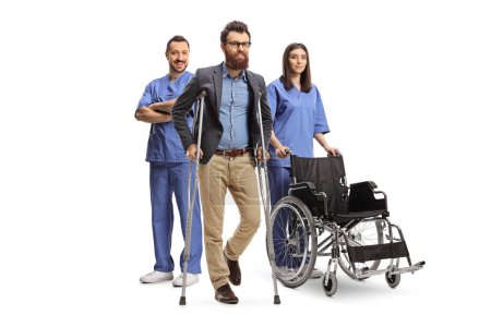 Photo for Male and female health care workers in blue uniforms posing behind a bearded man isolated on white background - Royalty Free Image