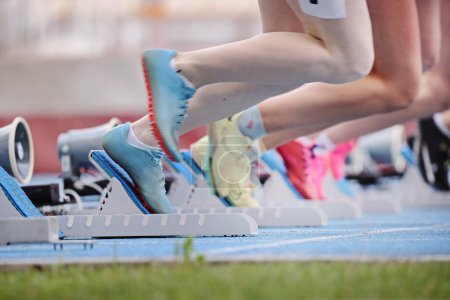 Photo for Athletes beginning a race on starting blocks at a running track - Royalty Free Image