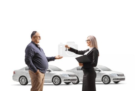 Photo for Businesswoman returning car keys to a mature man isolated on white background - Royalty Free Image