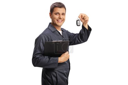 Foto de Mecánico automático sosteniendo un portapapeles y las teclas del coche aislados sobre fondo blanco - Imagen libre de derechos