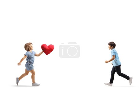 Foto de Niña llevando un corazón rojo y corriendo hacia un niño aislado sobre fondo blanco - Imagen libre de derechos