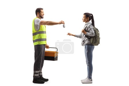 Téléchargez les photos : Plan complet d'un agent d'assistance routière donnant des clés de voiture à une étudiante isolée sur fond blanc - en image libre de droit