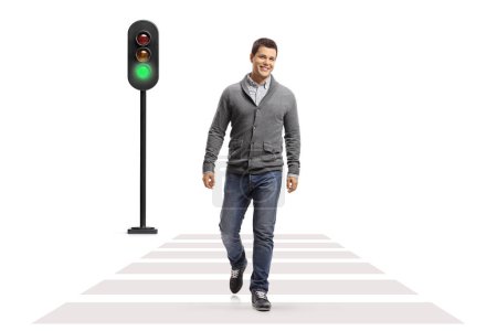 Photo for Full length portrait of a young smiling man walking at a pedestrian crossing isolated on white background - Royalty Free Image