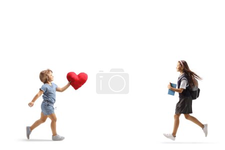Foto de Niña llevando un corazón rojo y corriendo al encuentro de su hermana aislada sobre fondo blanco - Imagen libre de derechos