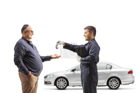 Photo for Auto mechanic returning a car key to a mature man isolated on white background - Royalty Free Image