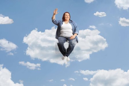 Photo for Overweight young woman sitting on a cloud and waving - Royalty Free Image
