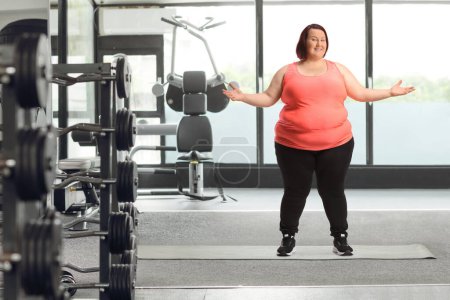 Photo for Cheerful overweight woman in sportswear posing inside a gym - Royalty Free Image