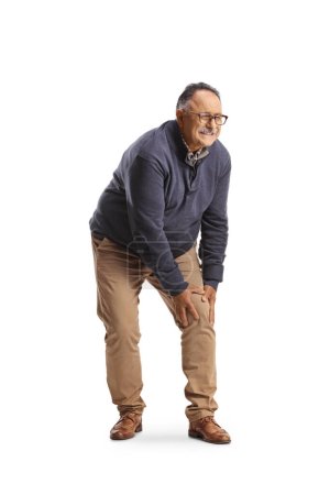 Photo for Mature man standing and holding his painful knee isolated on white background - Royalty Free Image