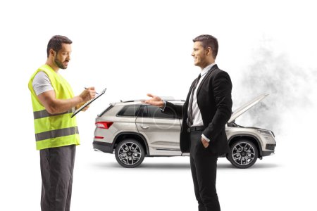 Téléchargez les photos : Homme expliquant un problème de voiture et un agent d'aide routière écrivant un document isolé sur fond blanc - en image libre de droit